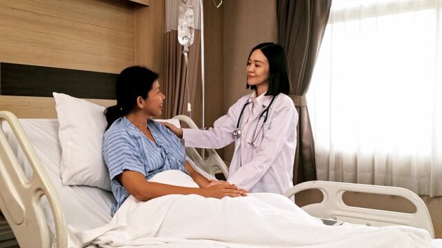 A doctor comforts a patient in a hospital bed during a consultation, with an IV drip and medical equipment in a bright, modern room.