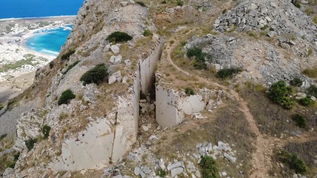 Drohnenaufnahme eines Berges mit Klippen und Meer in Sizilien