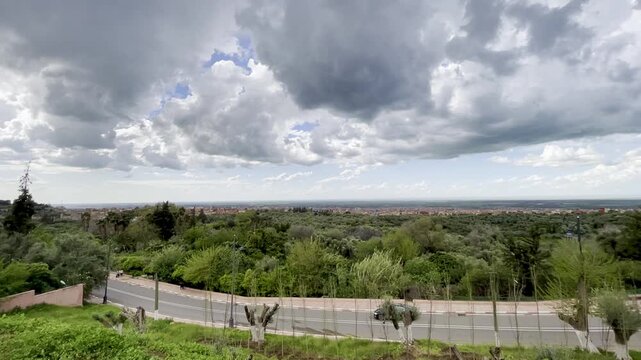 Beni Mellal, Morocco &ndash; March 26, 2026: From a vantage point beneath the Beni Mellal kasbah, I filmed the main road as it wound through the city. Even with a cloudy sky, the greenery of the trees and t