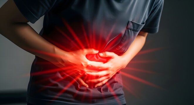Severe abdominal pain and stomach ache symptom. Gastroenterology health and emergency medical care. Person wearing a t-shirt holding their belly with intense red light rays