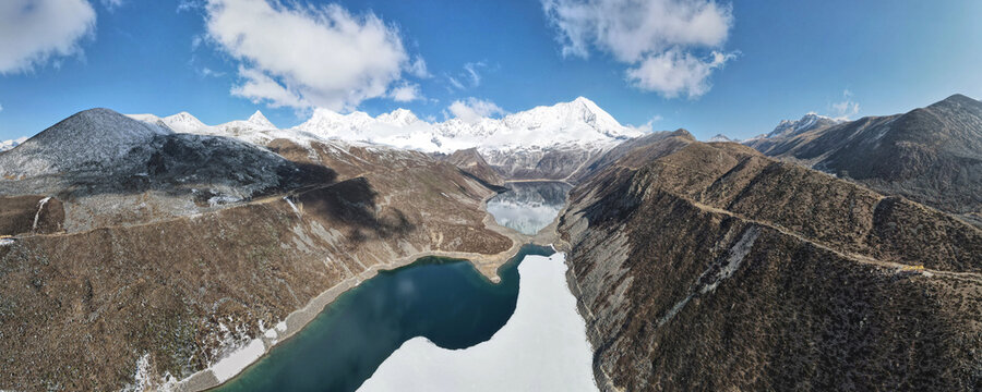 Wide panoramic drone view of Kula Kangri snow mountains and alpine lake Tibet