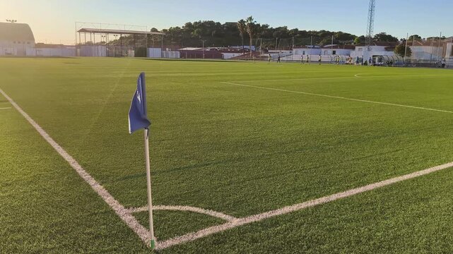 Football corner flag on artificial turf at sunset
