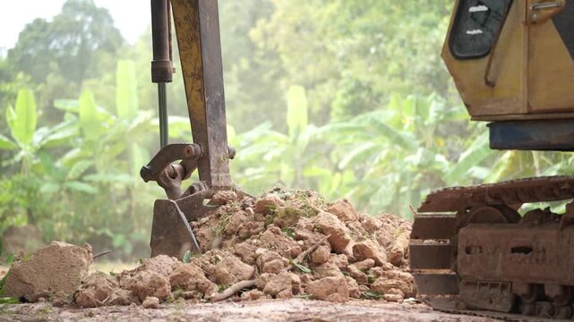 Heavy Machinery in Action: A yellow excavator, the epitome of power and precision, meticulously excavates earth at a construction site. This image shows the raw power of the machinery.