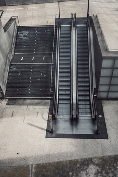 Empty modern urban escalator with vertical concrete stairs and steps for transport showing clean architecture structure and minimalist travel space