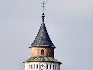 Ancient turret with weather vane. Old fashioned turret showcasing clock face and weather vane detail © Vladimir