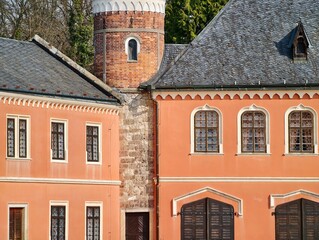 Vivid pink estate with turreted architecture and detailed craftsmanship under afternoon light © Vladimir
