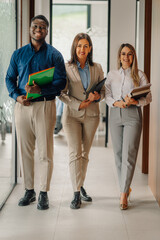 Fototapeta premium Diverse business team walking through office corridor