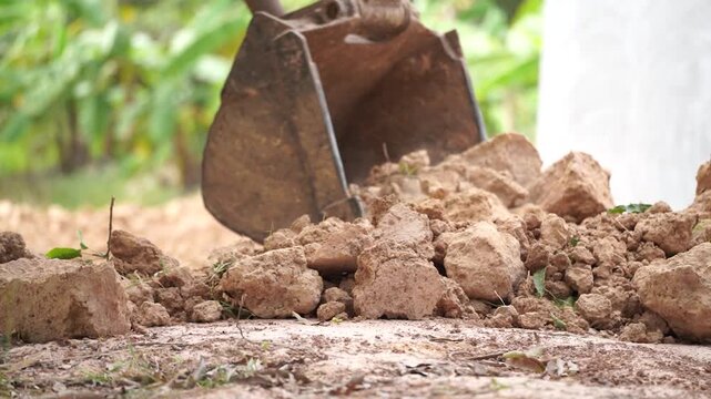 Excavator at Work: An excavator's bucket scoops up a mound of earth, showcasing raw power and the dynamism of construction. 