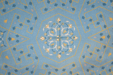 Obraz premium Blue geometric ornament pattern on fabric. Elegant mandala and symmetrical motif on light blue textile background. Classic ornamental design for fashion and decor.