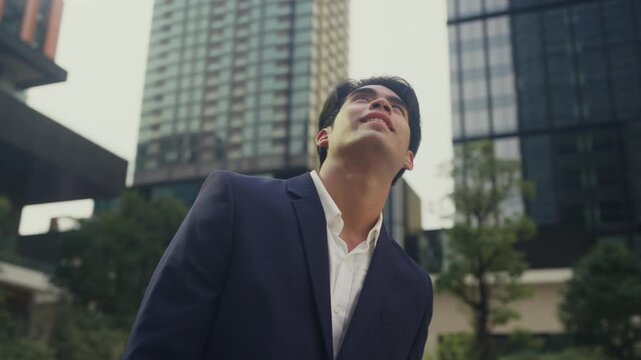 Successful young businessman stands among office towers, smiling with pride, embodying next-gen leadership, quiet ambition, and the drive of modern entrepreneurship in the corporate world