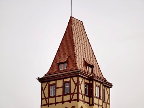 Rustic tower silhouette. Scenic village tower featuring steep terracotta roofing and wood beams