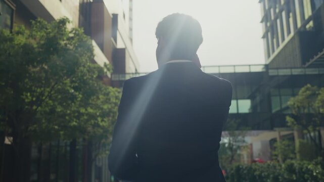 Young businessman talks with an investor via wireless earphones while heading to meeting, reflecting the fast-paced energy of startup culture, remote collaboration, and smart networking