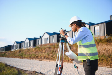 Naklejka premium Surveyor checking construction site with modern residential buildings