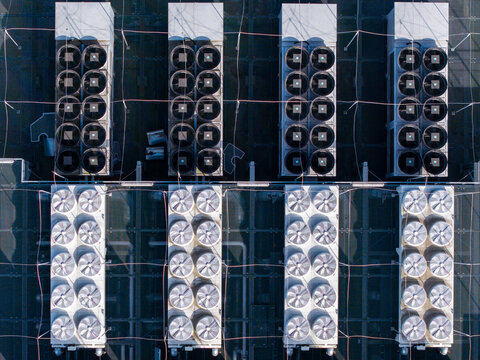 Aerial view of a symmetrical grid of rooftop HVAC units maintaining optimal temperature for a compute grid, Warsaw, Masovian Voivodeship, Poland.