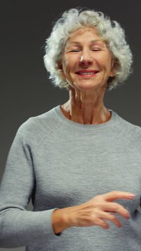 Happy senior woman 50-60 years old dancing. Energetic Joyful retired female with grey hair enjoying health and positive emotions, celebrating life and beauty of aging. Grandmother fun