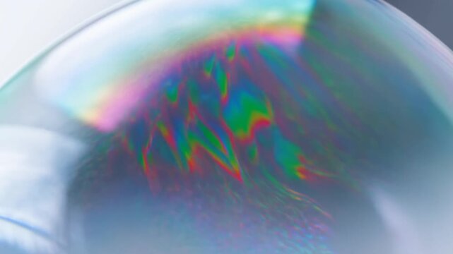 Close-up of a soap bubble reflecting vibrant colors and patterns. Represents the beauty of nature and the joy of childhood play