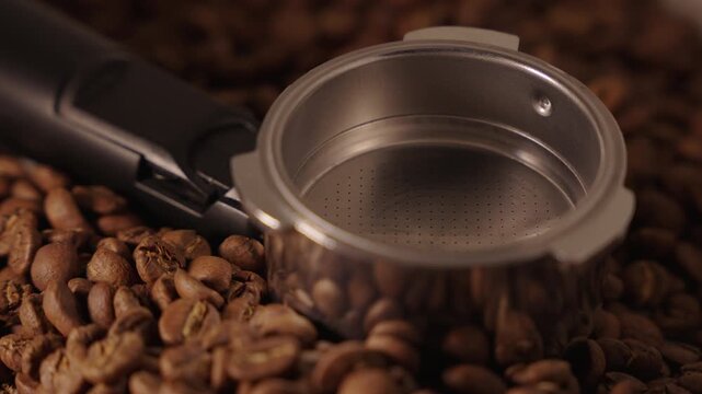 An empty portafilter laying on cofffee beans