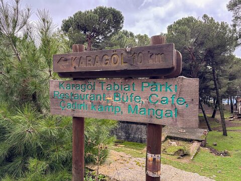 Rustic wooden signpost directing to Karagol Nature Park in the forest