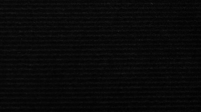 Black Corrugated Paper Texture.Dark ribbed cardboard background loop with subtle moving light and grunge.