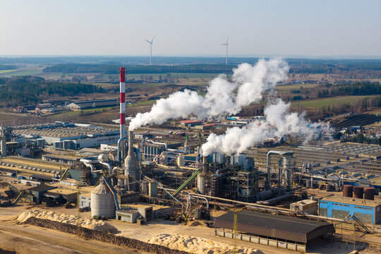 Aerial view of wood factory processing raw timber and turning into materials for furniture while smoke plumes emit from the industrial plant, Grajewo, Podlaskie Voivodeship, Poland.