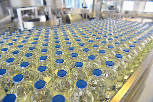 medical products manufacturing in a modern factory - glass bottles with medications on conveyor belt