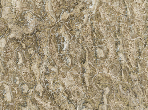 Aerial view of intricate patterns resembling parched earth, etched with fine lines like dried riverbeds, creating a textured tapestry of browns and creams, Walvis Bay, Namibia.