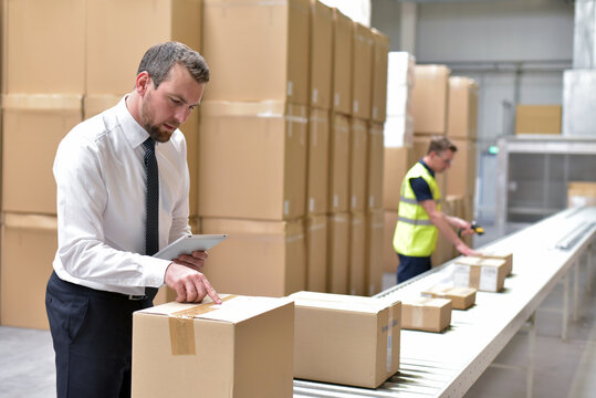 Worker in a warehouse in the logistics sector processing packages on the assembly line  - transport and processing of orders in trade