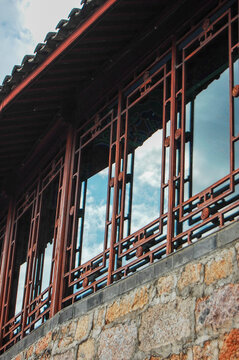 Traditional Chinese architecture with red wooden windows and stone walls