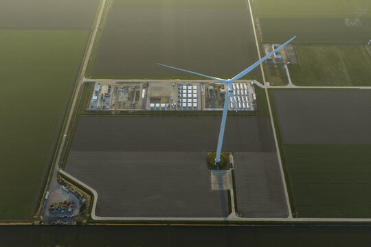 Aerial view of wind turbine powering energy storage units in netherlands