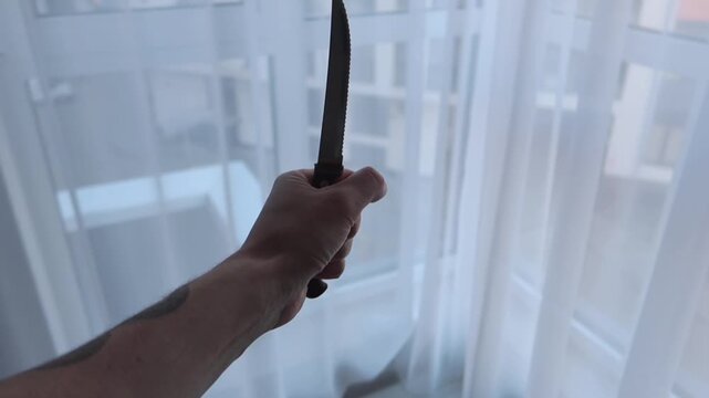 A man brandishing a sharp knife in a first person view