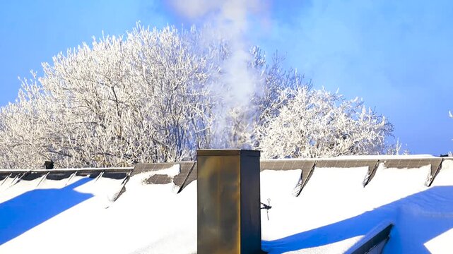 Smoking chimney on a snow covered roof with solar panels