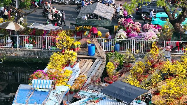 Aerial view of Binh Dong wharf in Ho Chi Minh city, Vietnam floating flower market during Tet Holiday. Boats filled with colorful flowers, bonsai trees, and ornamental plants are moored along canal
