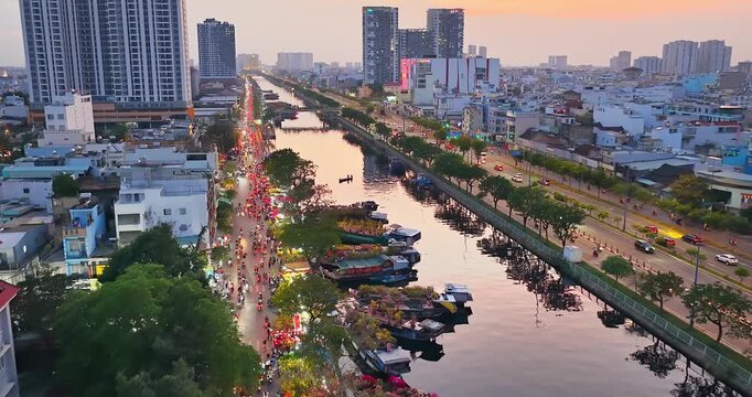 Aerial view of Binh Dong flower market wharf in Ho Chi Minh city, Vietnam during Tet Holiday season. Boats loaded with colorful flowers line the canal, creating a unique floating market atmosphere