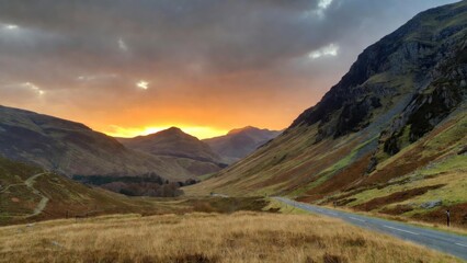 Fototapeta premium Winding valley road with hills at golden sunset light
