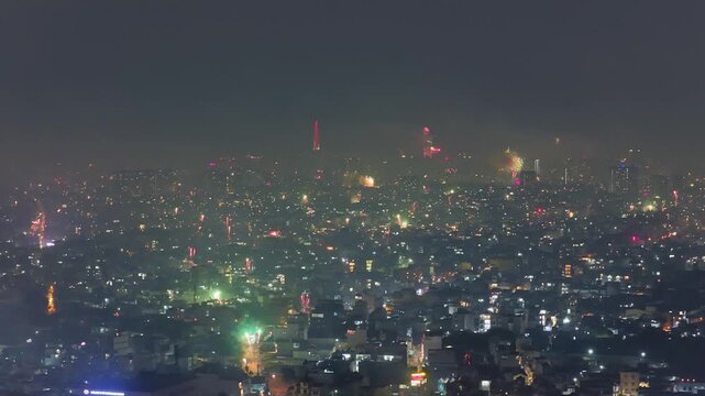 Aerial view of Saigon cityscape at Lunar New Year's Eve 2026, colorful fire works lighting the night skies with vivid multi colors in Southern Vietnam. Night celebration