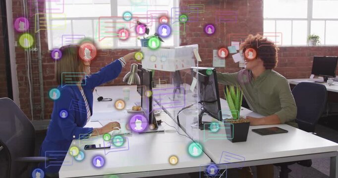 Man right handing printed sheet to woman left, both inspecting charts while animated icons flowing
