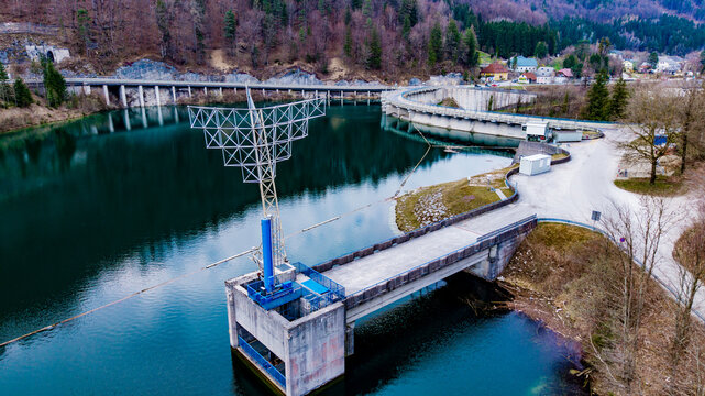 Aerial view of the stark concrete dam contrasting with the emerald water and the backdrop of the forested hills, Klaus an der Pyhrnbahn, Oberosterreich, Austria.