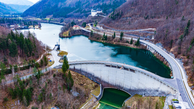 Aerial view of the Klaus Dam holding back the serene waters, castle perched above, embraced by the surrounding forest, Klaus an der Pyhrnbahn, Oberosterreich, Austria.