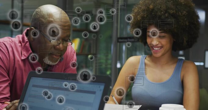 Senior mentor leaning to laptop, mentee reviewing docs causing UI icons overlaying education