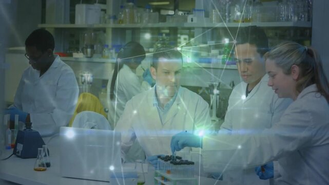 Researchers checking laptop protocol, pipetting rack while network tracing sample flow in lab