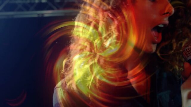 Lead singer gripping mic, singing on music stage, projection swirling across performer and truss