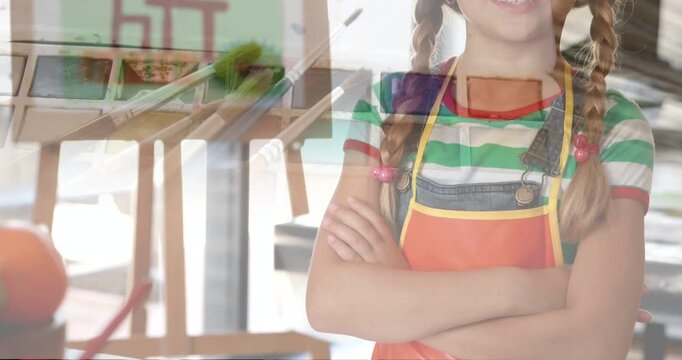 Overlay fading, girl in apron standing with crossed arms smiling showing easel palette to show art