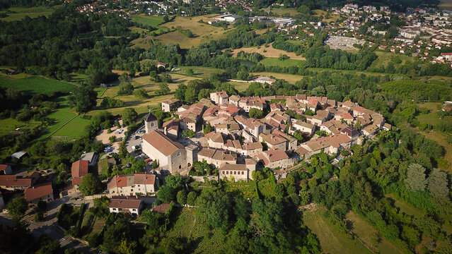 Aerial view of the medieval walled village with its ancient church and terracotta rooftops amidst lush greenery, Perouges, Auvergne-Rhone-Alpes, France.
