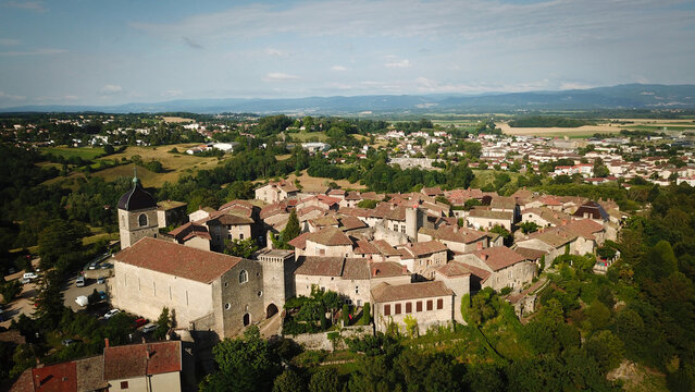 Aerial view of the ancient walled village with its reddish rooftops and stone buildings nestled amidst lush green hills, Perouges, Auvergne-Rhone-Alpes, France.