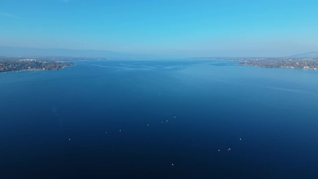 Aerial: Lake Geneva during the day with skyline and blue water in Geneva, Switzerland, establishing drone shot