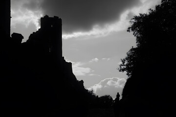 Obraz premium Silhouette of Ancient Ruins at Sunset with Dramatic Clouds