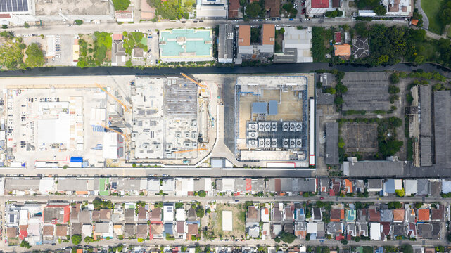 Aerial view of the STT Bangkok 1 data center facility and adjacent construction site with cooling units and urban rooftops in Krung Thep Maha Nakho, Thailand.