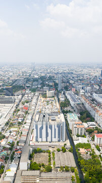 Aerial view of the STT Bangkok 1 data center building surrounded by dense urban residential areas and city skyline under a hazy sky in Krung Thep Maha Nakho, Thailand.