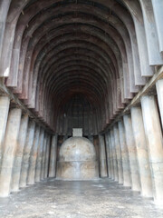 Obraz premium Interior view of the ancient Buddhist rock-cut Chaityagriha prayer hall with a monolithic Stupa and wooden ribbed ceiling at Bhaja Caves, India.
