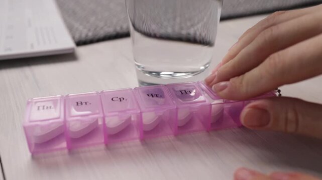 hands close pill organizer after preparing doses, medication adherence and routine management